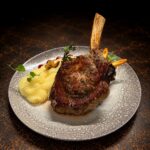 Tomahawk de vițel de lapte cu piure de cartofi și ceapă caramelizată cu trufe